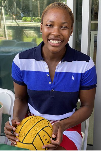 Johnson signed a water polo ball during her visit and hand lunch with the girls water polo team.