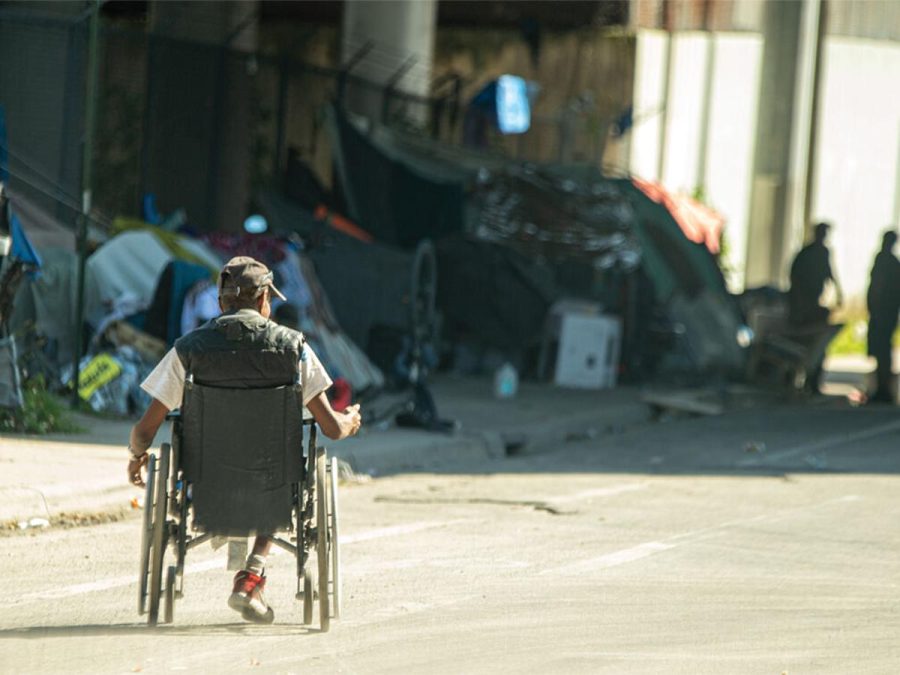 Disabled homeless man makes his way towards a tent city on 11th Street