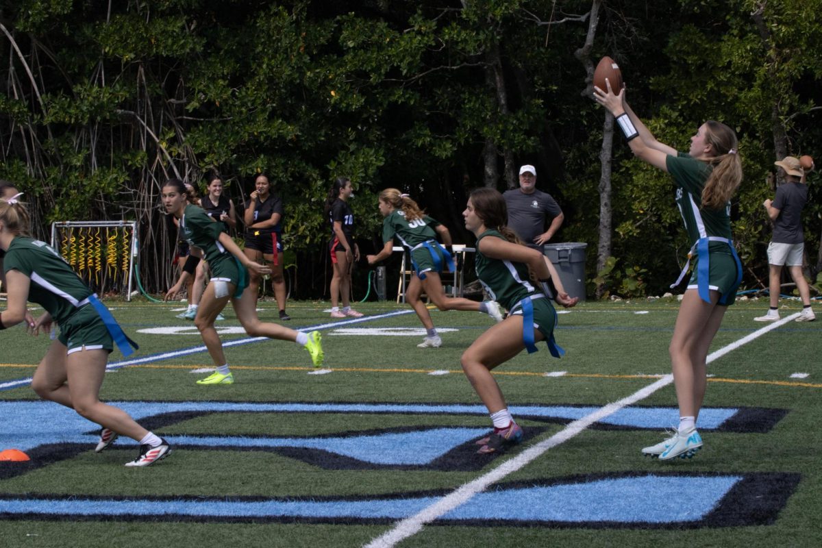 Center Lily Namias '25 (running left) hikes the ball to quarterback Penelope Galvin '28 (right) in Senior Night game vs. Westwood Christian School