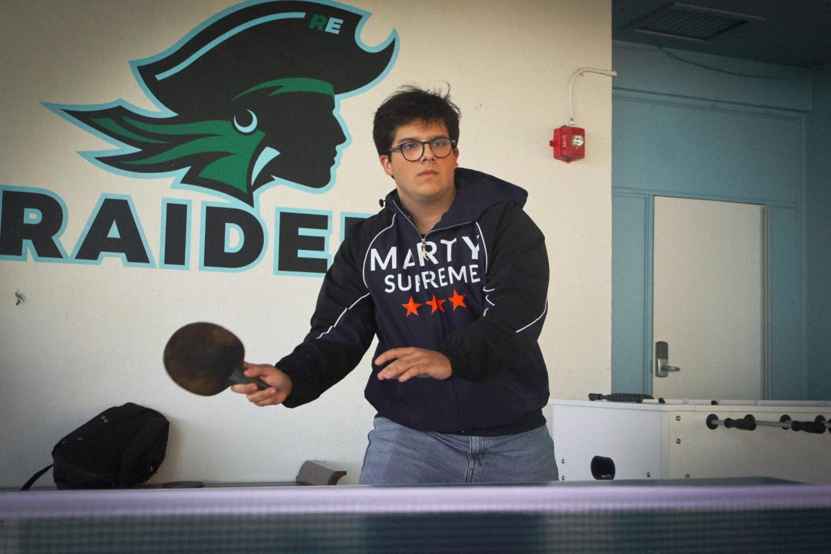 Christopher Tsialas '26 plays ping pong on the senior deck in his Marty Supreme jacket